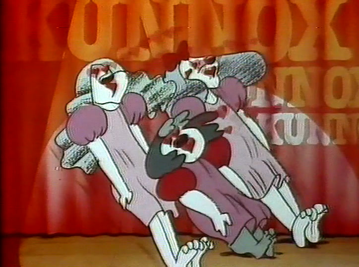 The dogs crowd forward on the lit stage, arms and legs flung out.