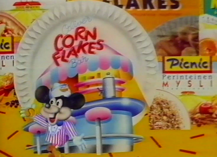 Picnic cereal packs in a drawn cereal landscape, Mickey Mouse and Donald Duck alongside.