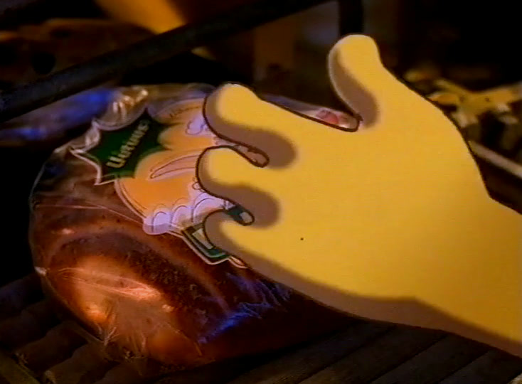 A large yellow cartoon hand reaches down for a wrapped loaf on the rack