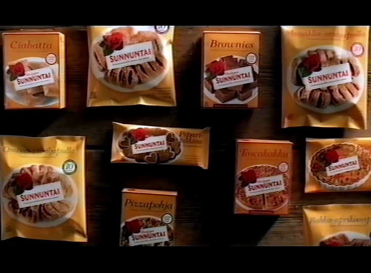 A wooden wall hung with the whole Sunnuntai pack range, a red rose on every label