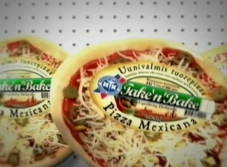 A Mexicana pizza tilts towards the camera against a perforated white wall