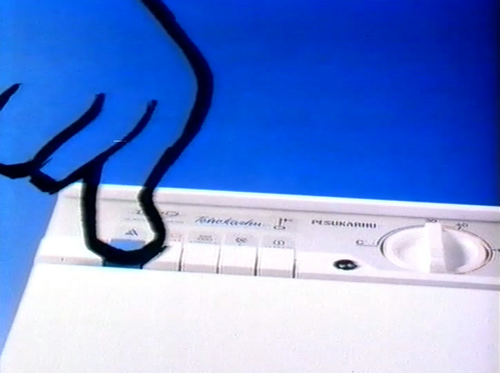 A drawn black paw presses a button on the machine’s real control panel, seen close up.