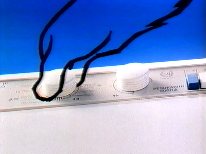 The same paw reaches for the programme dial; the panel reads PESUKARHU 9000 A.
