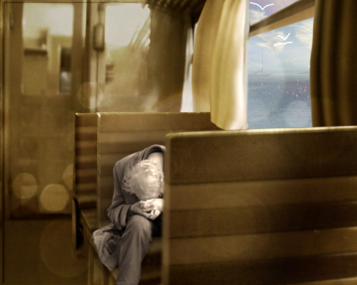 A person lies curled asleep on a train bench, sea and gulls beyond the window.