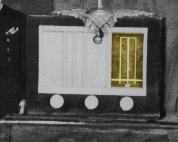 Close view of an old radio, its tuning dial panel white with one section tinted yellow.