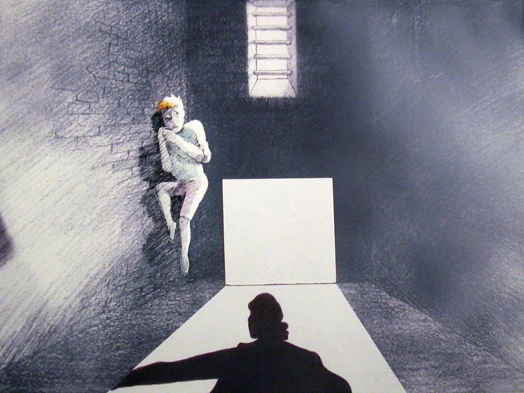 Still from Some Protection, Josie curled against the wall of a prison cell, a barred window above her and light falling across the floor
